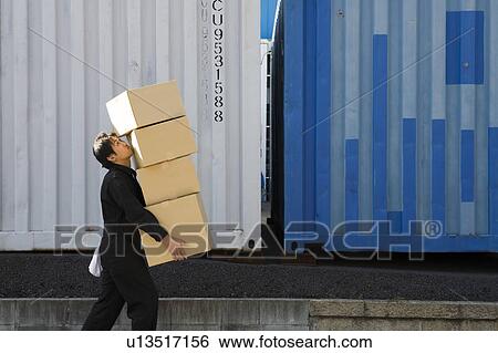 Stock Photograph - Young worker carrying boxes. Fotosearch