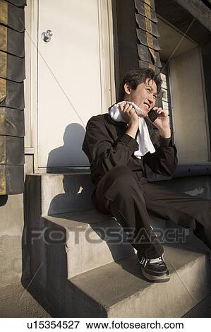 Stock Photo - Young worker talking over mobile phone. Fotosearch