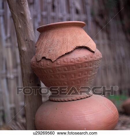 Stock Image - Stack of Pottery leaning against a tree. Fotosearch