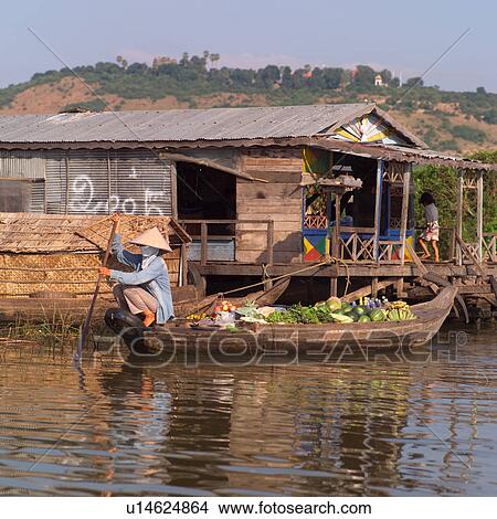 Picture - Asian woman paddling a boat. Fotosearch