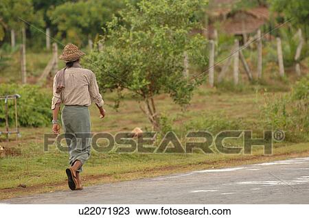 Burmese man walking down roadway View Large Photo Image Stock Image - Burmese man walking down roadway. Fotosearch