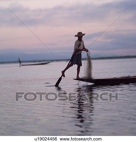 Stock Photograph - Intha fisherman in his flat-bottomed boat. Fotosearch