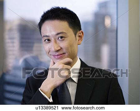 Businessman in office, hand on chin, portrait View Large Photo Image Stock Image - Businessman in office, hand on chin, portrait. Fotosearch