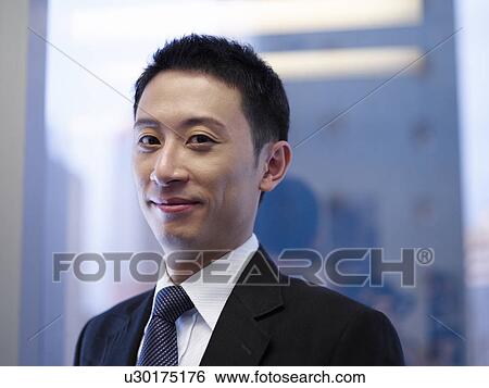 Stock Photograph - Businessman standing by window, Close up. Fotosearch