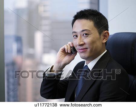 Businessman using mobile phone, smiling View Large Photo Image Stock Photo - Businessman using mobile phone, smiling. Fotosearch