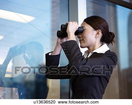 Stock Image - Businesswoman looking through binoculars. Fotosearch