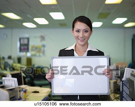Stock Photograph - Businesswoman woman holding blank white board. Fotosearch