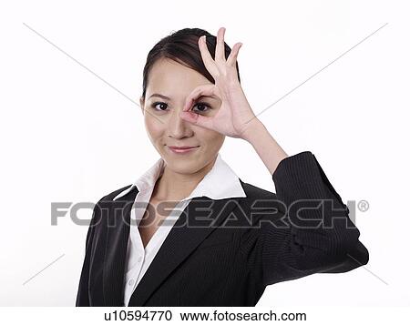 Businesswoman gesturing ok sign with fingers over eye View Large Photo Image Stock Image - Businesswoman gesturing ok sign with fingers over eye. Fotosearch
