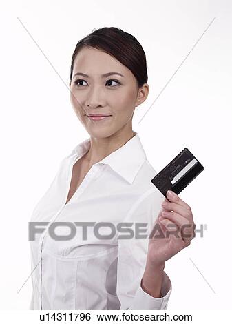 Stock Photograph - Businesswoman Holding a Credit Card Looking Away. Fotosearch
