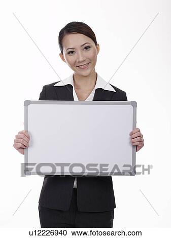 Stock Image - Businesswoman holding whiteboard. Fotosearch