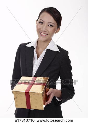 Businesswoman holding wrapped gift, smiling, portrait View Large Photo Image Stock Image - Businesswoman holding wrapped gift, smiling, portrait. Fotosearch