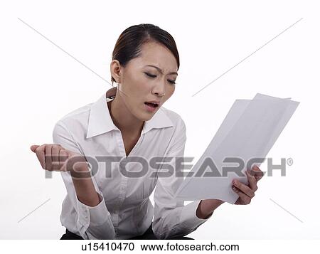 Stock Image - Businesswoman looking at documents. Fotosearch