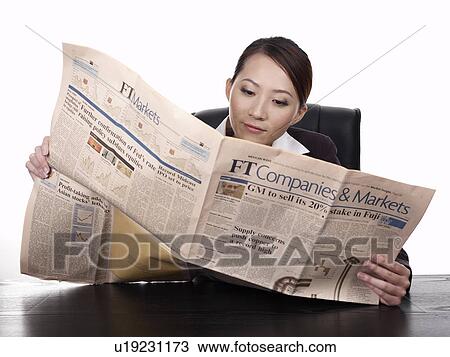 Stock Image - Businesswoman reading newspaper. Fotosearch