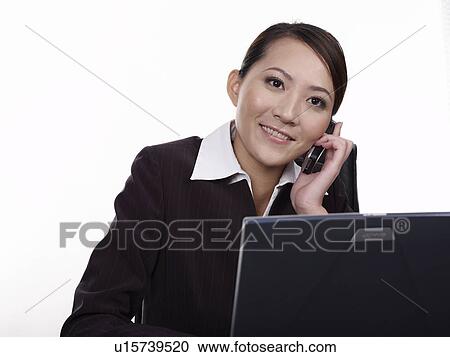 Stock Image - Businesswoman talking on mobile phone. Fotosearch