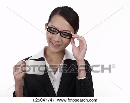 Stock Photo - Businesswoman with spectacles, holding a coffee cup. Fotosearch
