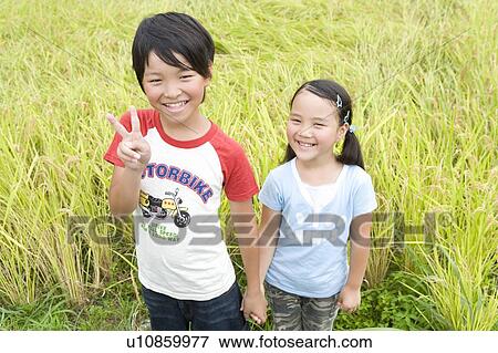 Stock Photo - Boy and girl holding hands in rice paddy . Fotosearch
