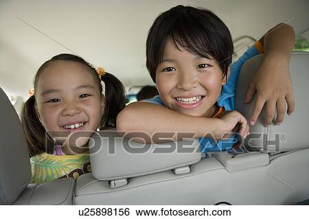 Boy and girl inside van, looking back from back seat View Large Photo Image Stock Photograph - Boy and girl inside van, looking back from back seat . Fotosearch