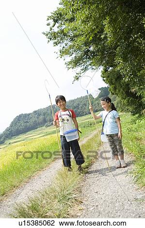 Boy and girl with butterfly net, standing along the gravel path View Large Photo Image Stock Image - Boy and girl with butterfly net, standing along the gravel path. Fotosearch