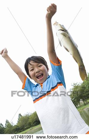 Boy holding a fish View Large Photo Image Stock Image - Boy holding a fish. Fotosearch