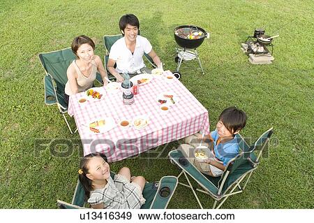 Families Having Lunch at Table on Grass Field View Large Photo Image Stock Photo - Families Having Lunch at Table on Grass Field. Fotosearch