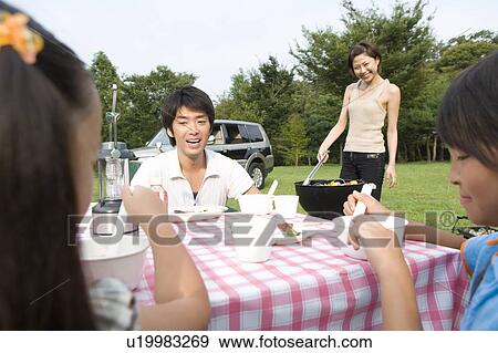 Families Having Lunch at Table on Grass Field View Large Photo Image Stock Photo - Families Having Lunch at Table on Grass Field. Fotosearch