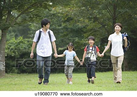 Stock Image - Families Walking in a Line on Grass Field. Fotosearch