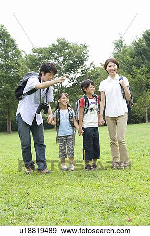 Stock Photo - Family holding hands, walking in field. Fotosearch