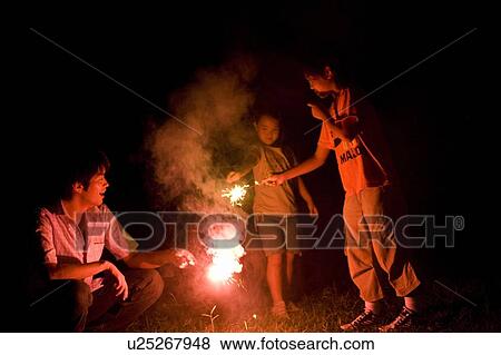 Family Playing with Hand-Held Fireworks Together View Large Photo Image Stock Photo - Family Playing with Hand-Held Fireworks Together. Fotosearch