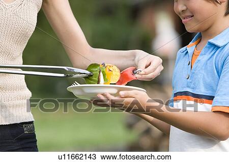 Mother serving grilled barbecue to son View Large Photo Image Stock Image - Mother serving grilled barbecue to son. Fotosearch