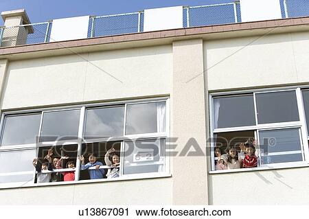 Stock Image - Elementary School Students Looking Outside of Window. Fotosearch