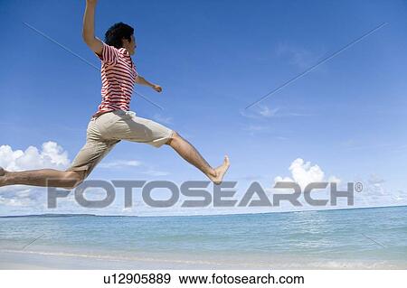 Man jumping on beach, Saipan, USA View Large Photo Image Stock Photo - Man jumping on beach, Saipan, USA . Fotosearch