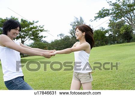 Young couple holding hands on lawn, smiling, Saipan, USA View Large Photo Image Stock Image - Young couple holding hands on lawn, smiling, Saipan, USA . Fotosearch