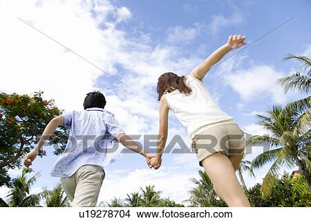 Picture - Young couple holding hands, Saipan. Fotosearch