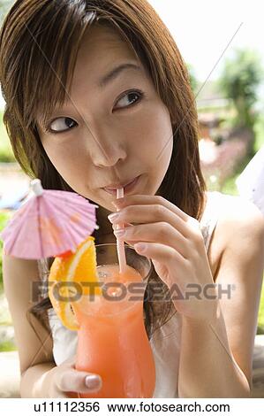Stock Photograph - Young woman drinking a cocktail, Saipan. Fotosearch