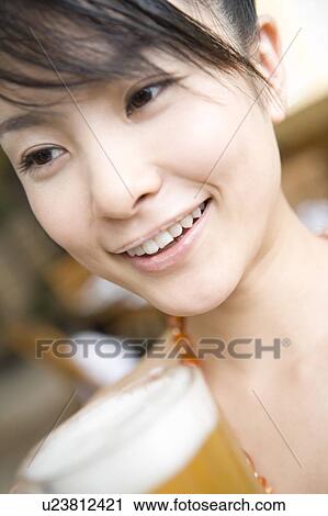 Stock Image - Young woman Holding a beer, Saipan. Fotosearch