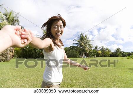Stock Image - Young woman pulling hands, Saipan. Fotosearch