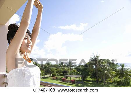 Stock Photo - Young woman stretching arms, Saipan. Fotosearch
