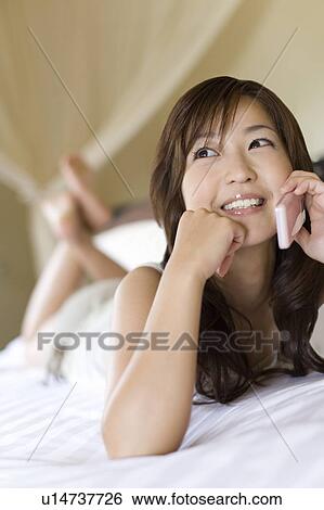 Stock Photograph - Young woman using a cell phone, Saipan, Focus on Foreground. Fotosearch