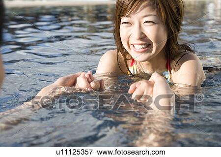 Stock Photo - Couple holding hands in Swimming Pool, Saipan. Fotosearch