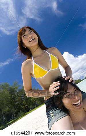 Man giving woman piggyback ride on beach, smiling, Saipan, USA View Large Photo Image Stock Photo - Man giving woman piggyback ride on beach, smiling, Saipan, USA . Fotosearch