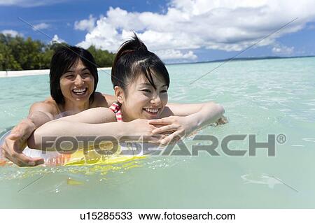 Stock Image - Young couple in the sea, Saipan, USA . Fotosearch