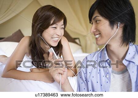 Young couple listening to Music, Saipan View Large Photo Image Stock Image - Young couple listening to Music, Saipan. Fotosearch