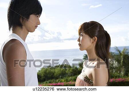 Stock Photograph - Young couple looking at each other, Saipan, USA . Fotosearch