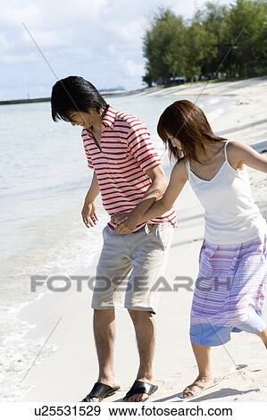 Stock Photo - Young couple on beach, smiling, Saipan, USA . Fotosearch