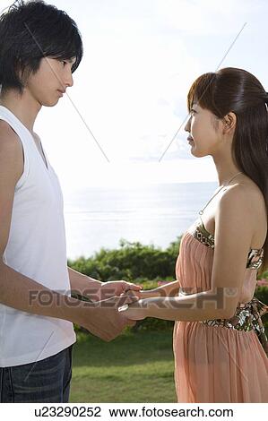 Young man holding woman's hands, standing face to face, Saipan, USA View Large Photo Image Stock Image - Young man holding woman's hands, standing face to face, Saipan, USA . Fotosearch