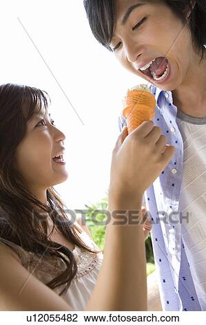 Stock Image - Young couple eating ice cream, Saipan. Fotosearch