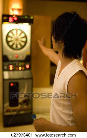 Stock Image - Young man playing darts, Saipan, Focus on Foreground. Fotosearch