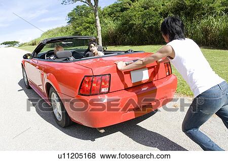 Young man pushing the car, women sitting in the car, Saipan, USA View Large Photo Image Stock Photo - Young man pushing the car, women sitting in the car, Saipan, USA . Fotosearch