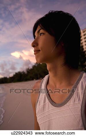 Young man smiling on beach in the evening, Saipan, USA View Large Photo Image Stock Image - Young man smiling on beach in the evening, Saipan, USA . Fotosearch