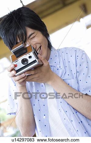 Young man using a Polaroid Camera, Saipan View Large Photo Image Stock Image - Young man using a Polaroid Camera, Saipan. Fotosearch